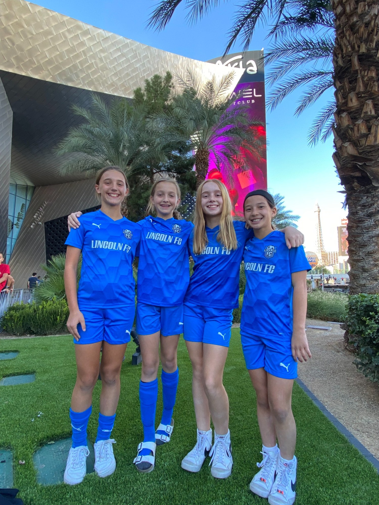 Four teammates in blue uniforms on a team trip